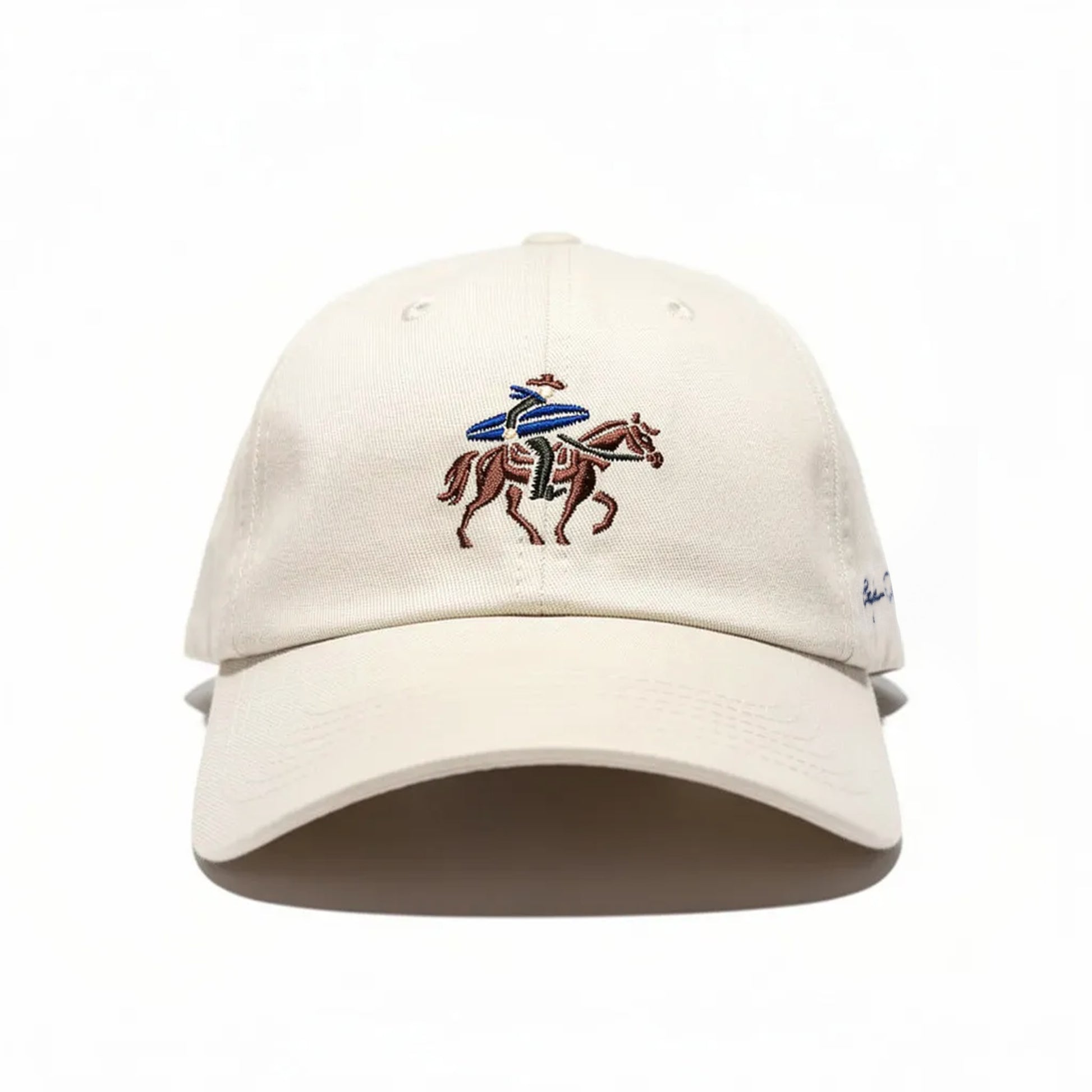 Beige cap with embroidered design of a surfing cowboy on a horse on a white background